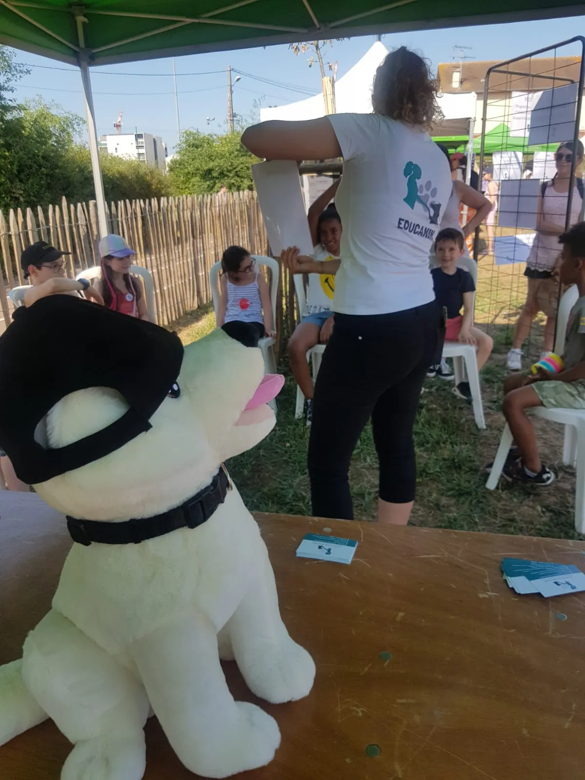 Laurie Jousse animant un atelier PECCRAM avec des enfants — peluche-chien démo en premier plan